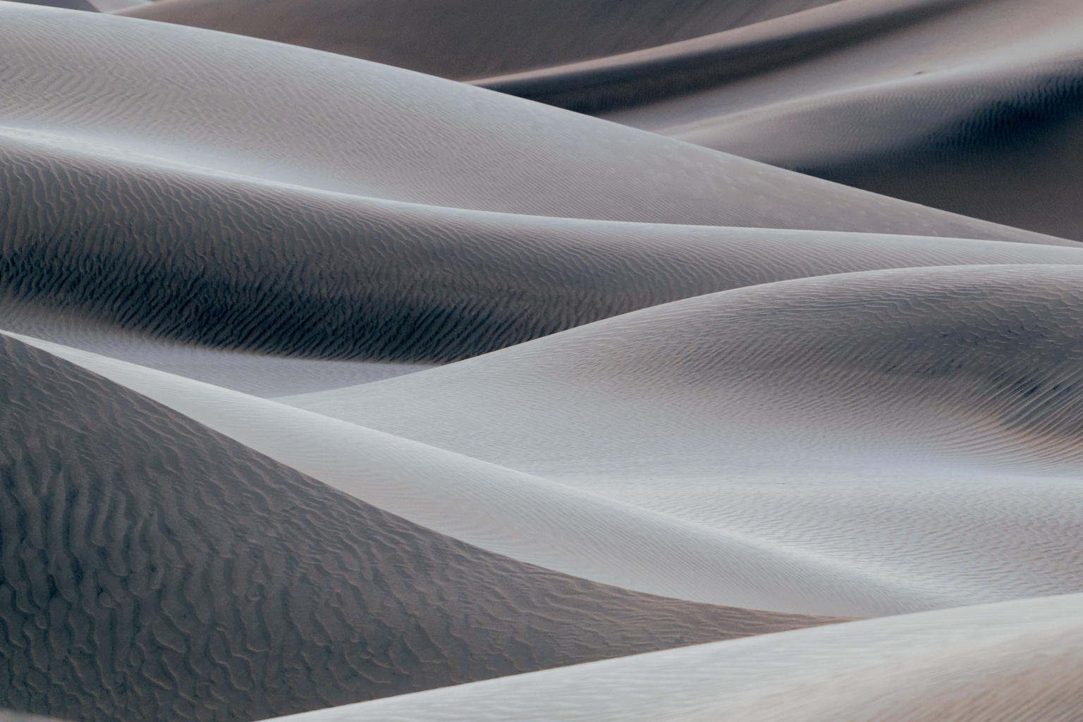 Soft overlapping sand dune curves in cool blue-grey light, minimal and abstract